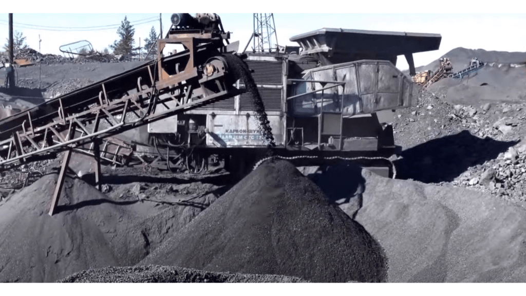 A large mining machine in operation, extracting and transporting shungite material at a mining site.