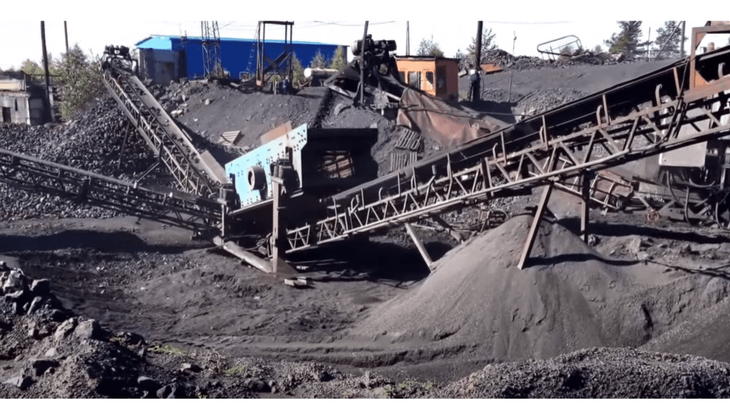 Machinery at a shungite excavation site in Karelia, Russia, displaying conveyor belts and piles of mined material.
